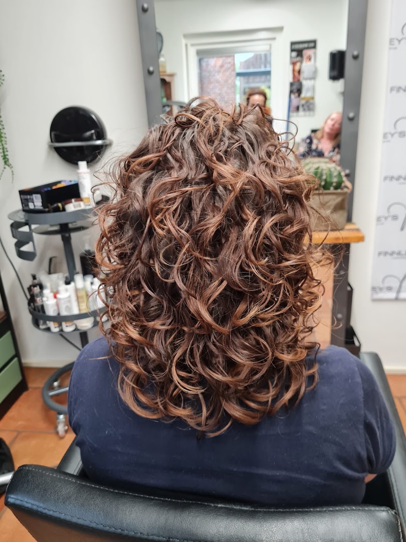 Bruine krullen met koperen highlights, geknipt en gestyled bij Triple C Hairlounge