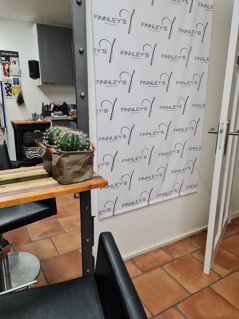 Het interieur van Triple C Hairlounge met terracotta vloer en de kappersstoelen